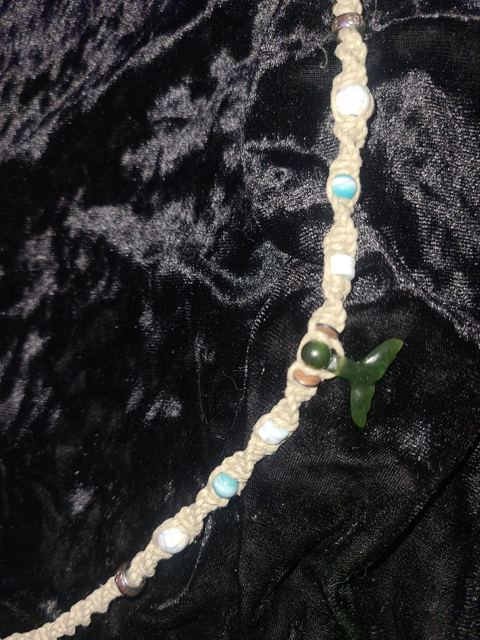 The whale tail necklace in natural light, showing the turquoise, white and copper beads