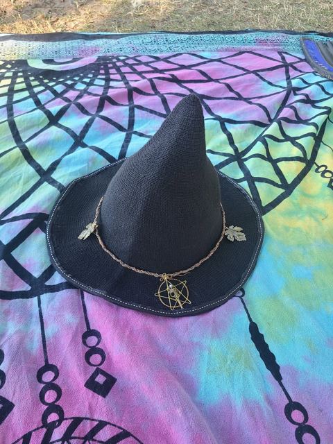 Black witch hat with a braided band, leaf charms and a wire-wrapped pentagram